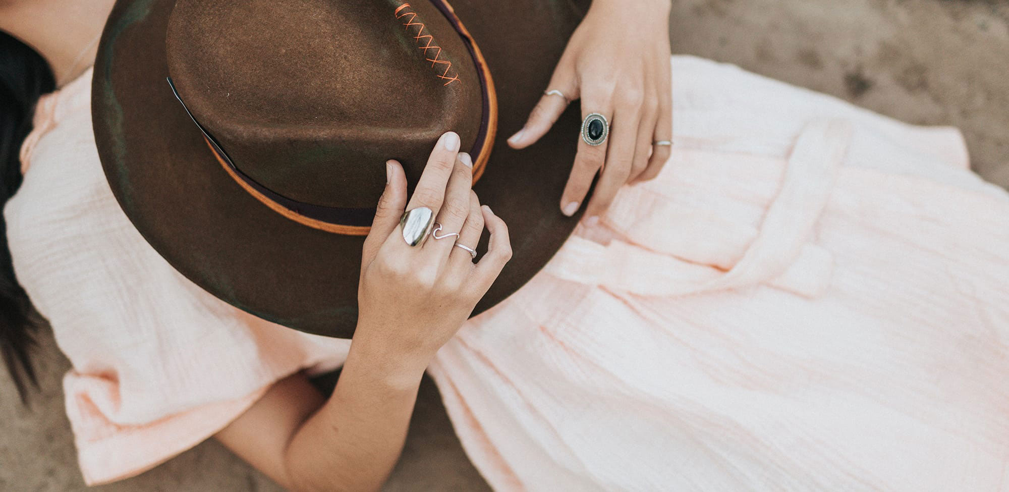 A woman laying down with a hat.